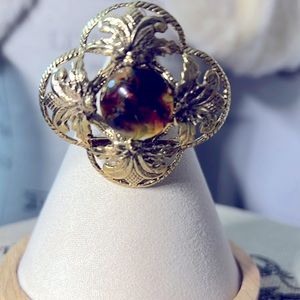 Gold brooch with brown swirl stone